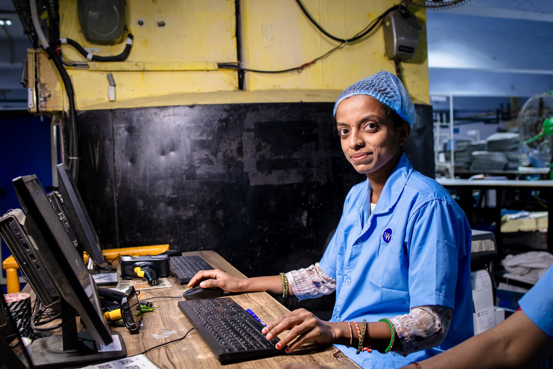 blue collar worker at computer station in factory